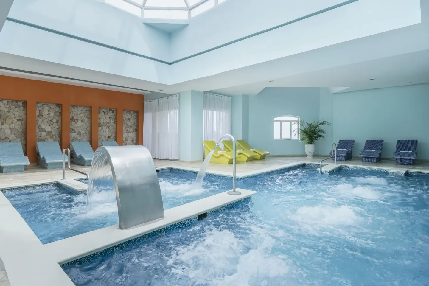 Hydrotherapy pool with waterfalls and lounge chairs at Iberostar Selection Rose Hall Suites.