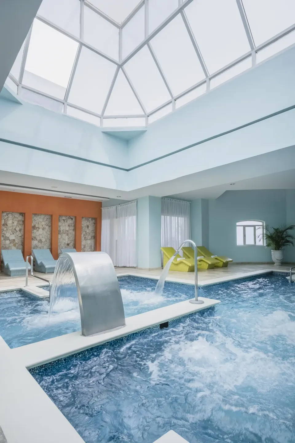 Indoor hydrotherapy pool with loungers at Iberostar Selection Rose Hall Suites.