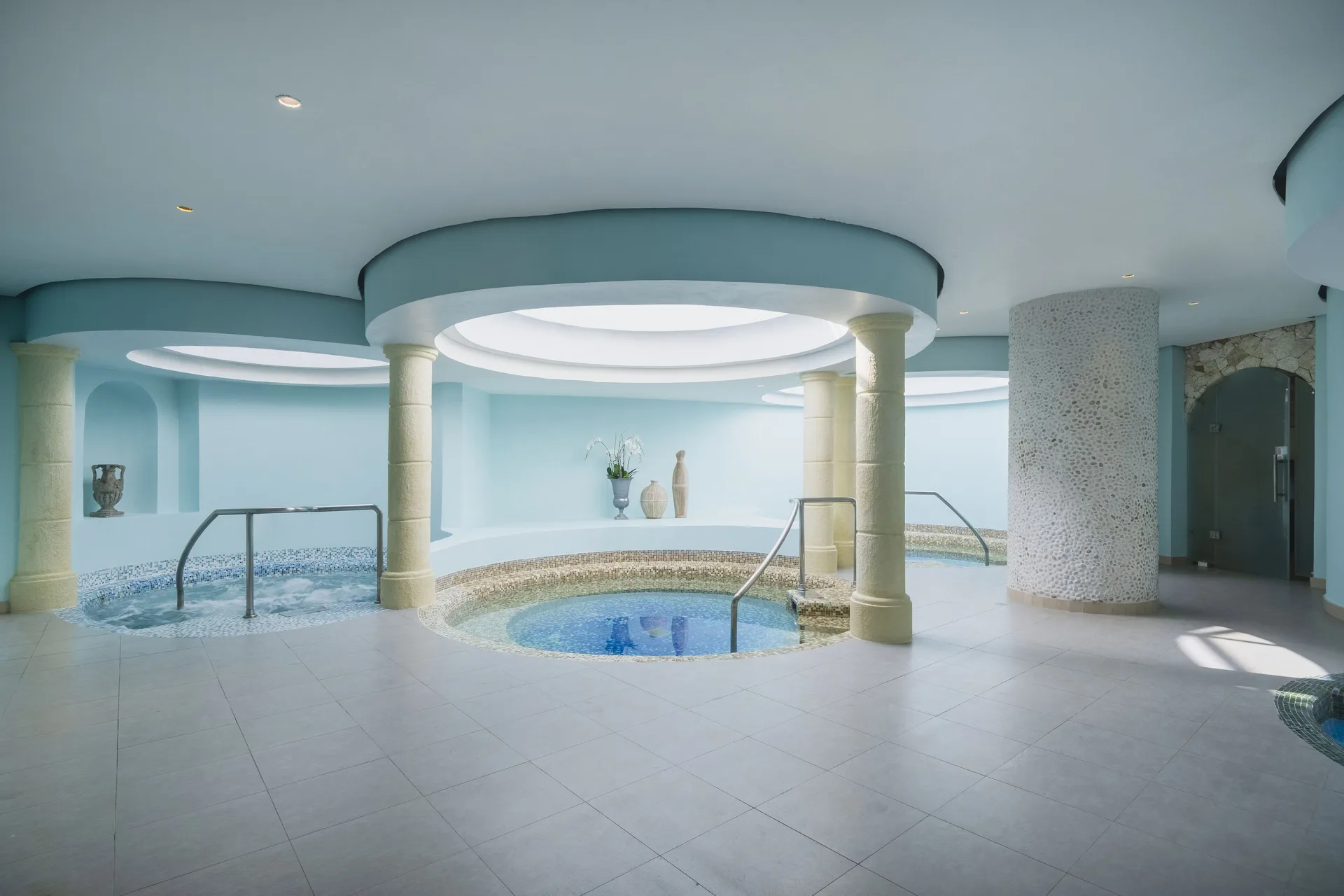 Indoor spa pools with columns and curved ceilings at Iberostar Selection Rose Hall Suites.
