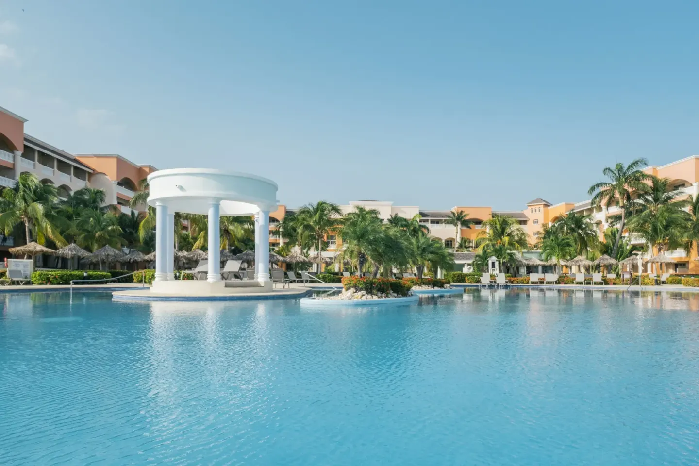 Main pool with white pavilion and resort buildings at Iberostar Selection Rose Hall Suites.