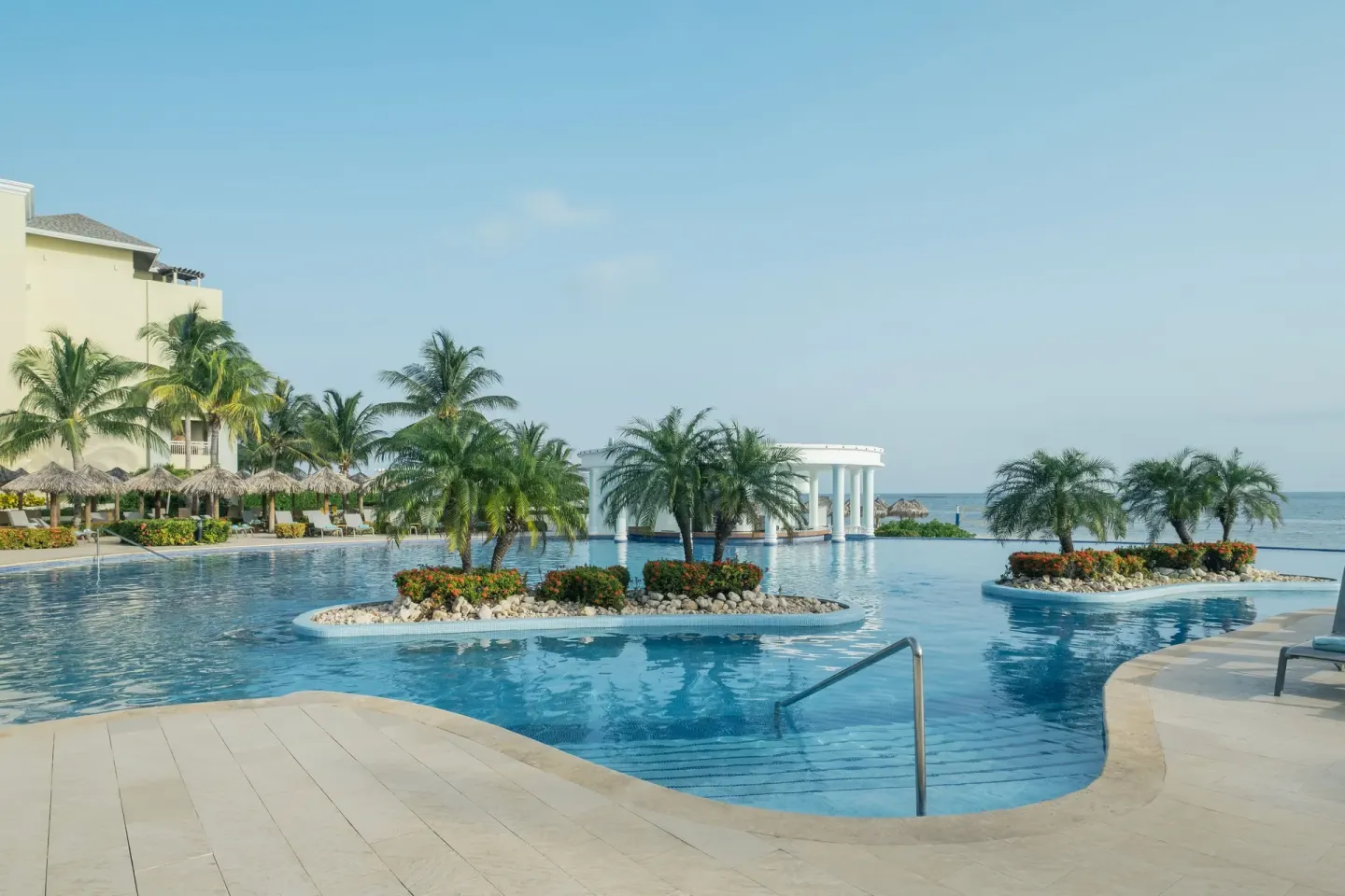 Oceanfront pool with landscaped islands at Iberostar Selection Rose Hall Suites.