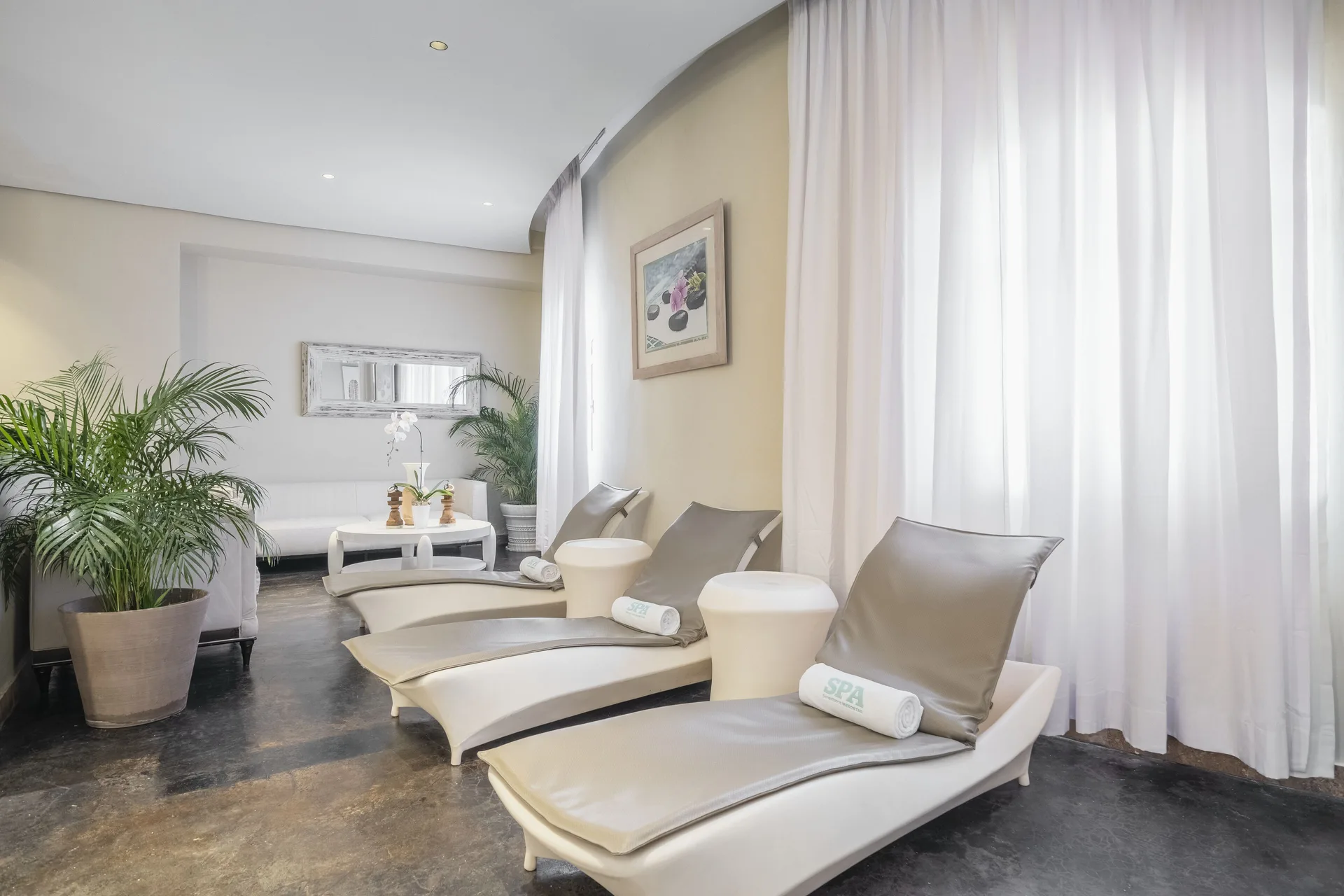 Spa relaxation loungers beside sheer curtains at Iberostar Selection Rose Hall Suites.