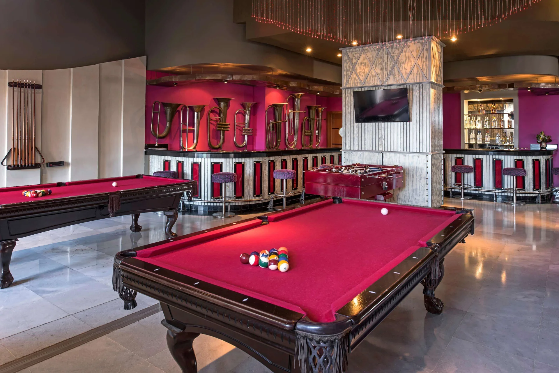 Sports bar with red pool tables at Iberostar Selection Rose Hall Suites.