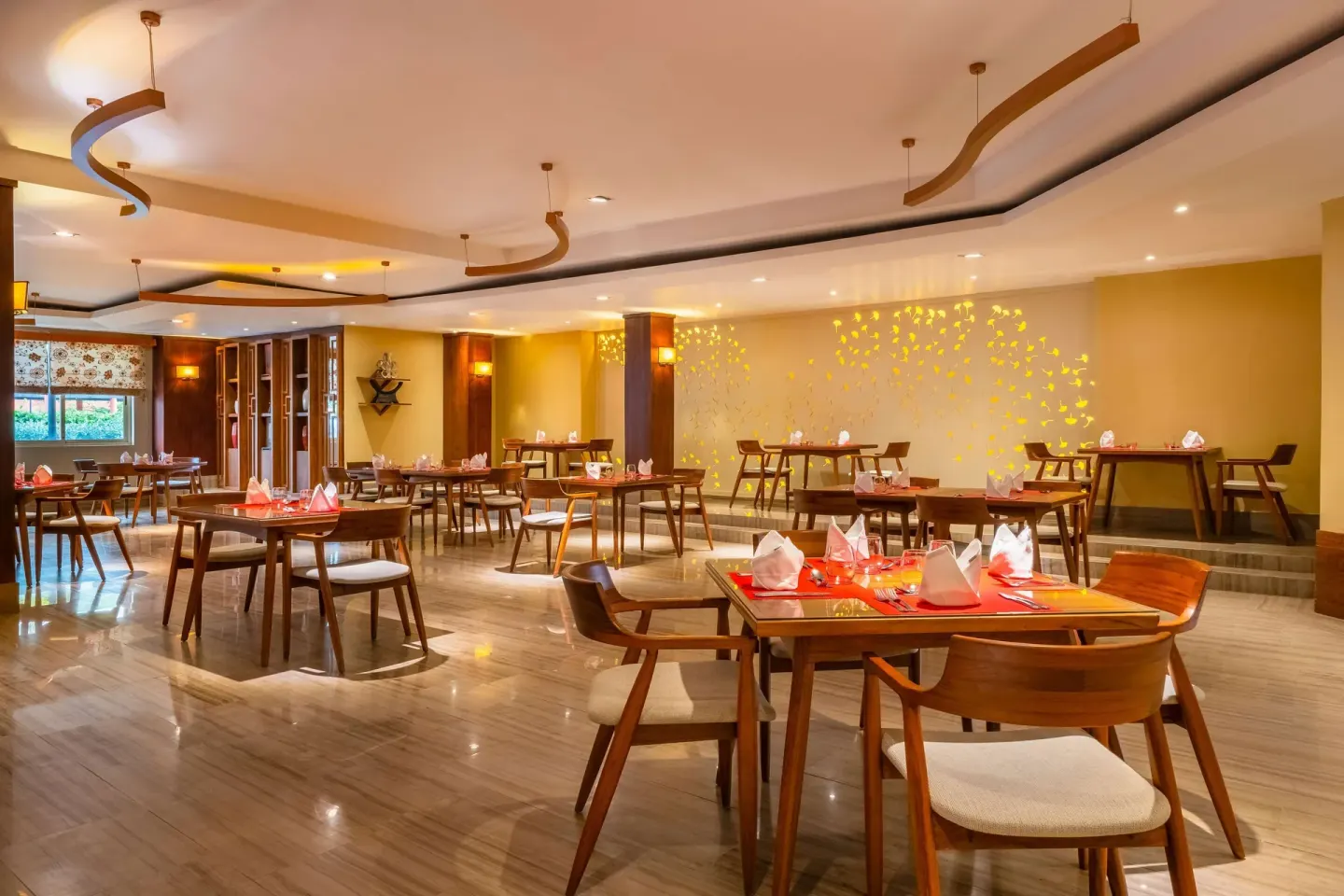 Set dining tables in a warm restaurant at Iberostar Selection Rose Hall Suites.