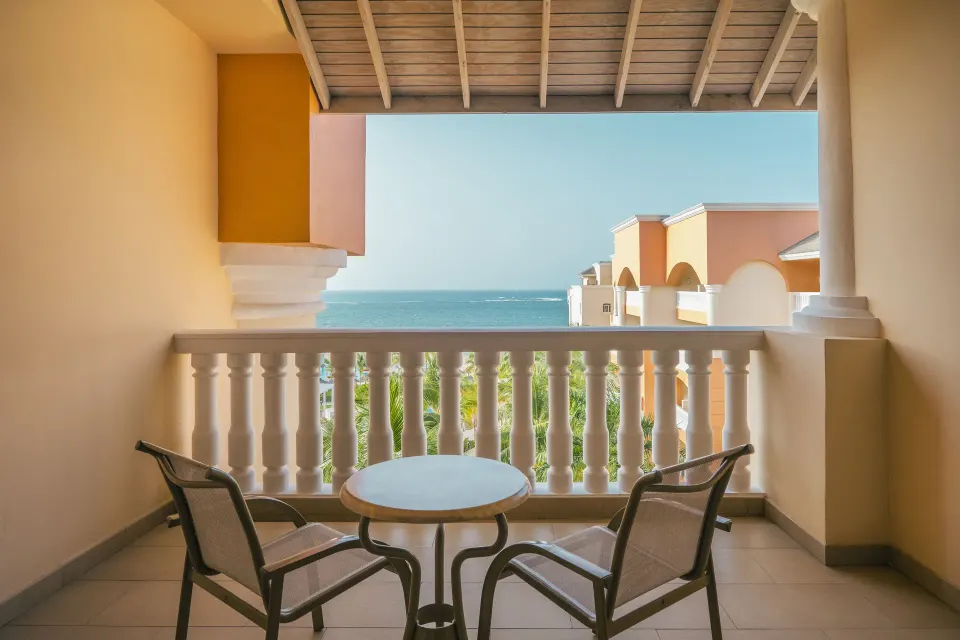 Junior Suite Ocean View balcony with chairs and sea view at Iberostar Selection Rose Hall Suites.