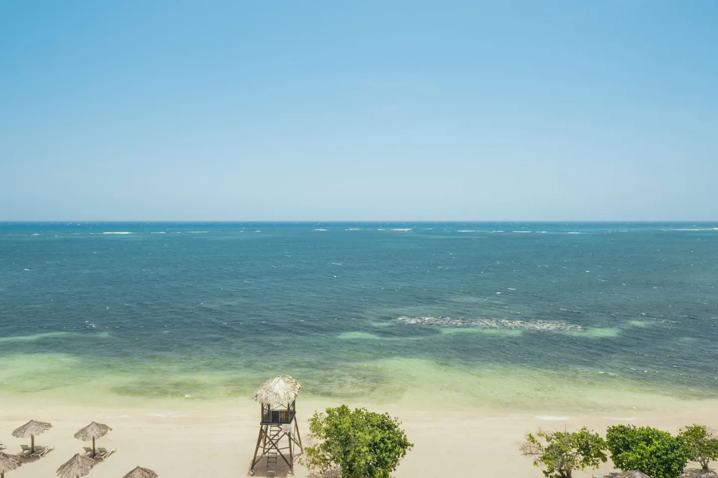 Oceanfront beach and turquoise water view from Iberostar Selection Rose Hall Suites.