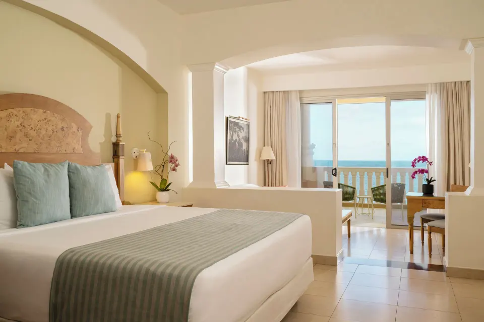 Junior Suite Oceanfront king bed with balcony view at Iberostar Selection Rose Hall Suites.