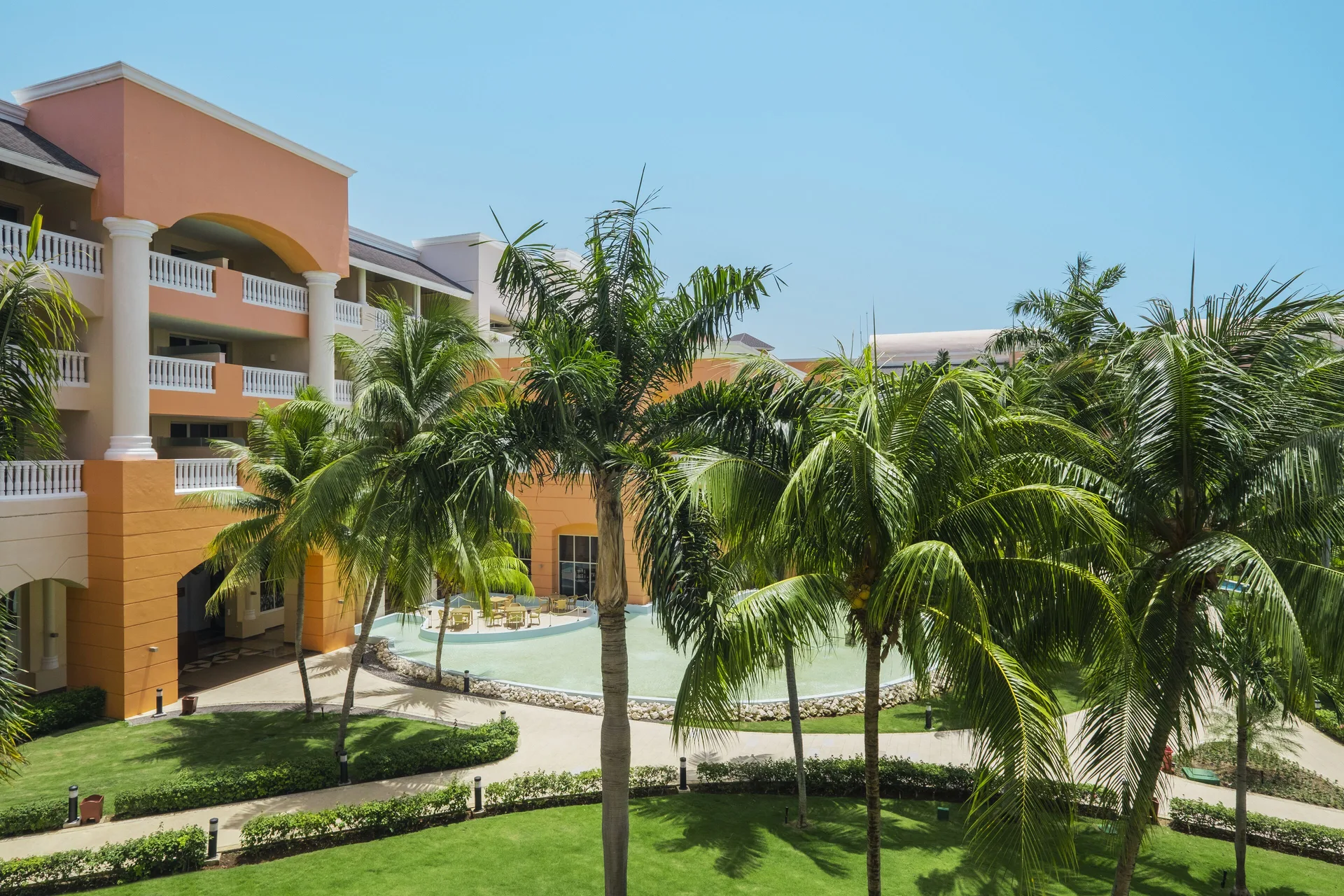 Junior Suite balcony view of palms and resort buildings at Iberostar Selection Rose Hall Suites.