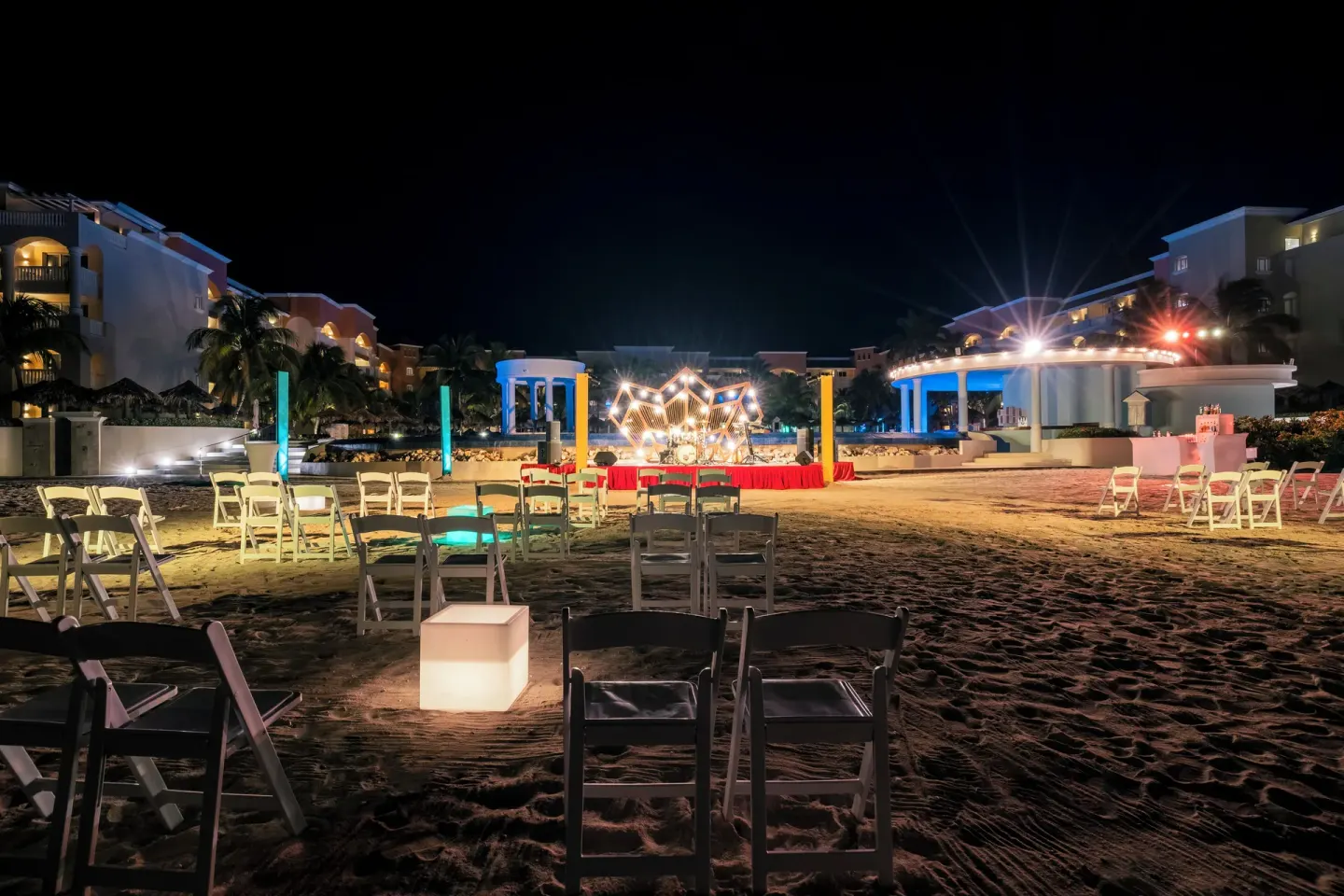 Beach event setup with chairs and a lit stage at Iberostar Selection Rose Hall Suites.