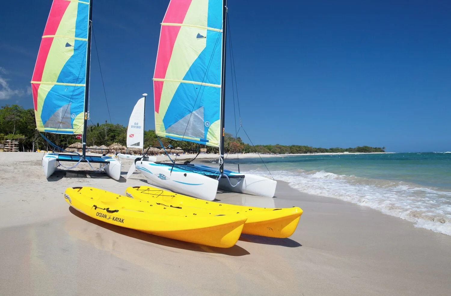 Kayak and sailboats lined up on the beach at Iberostar Waves Costa Dorada.