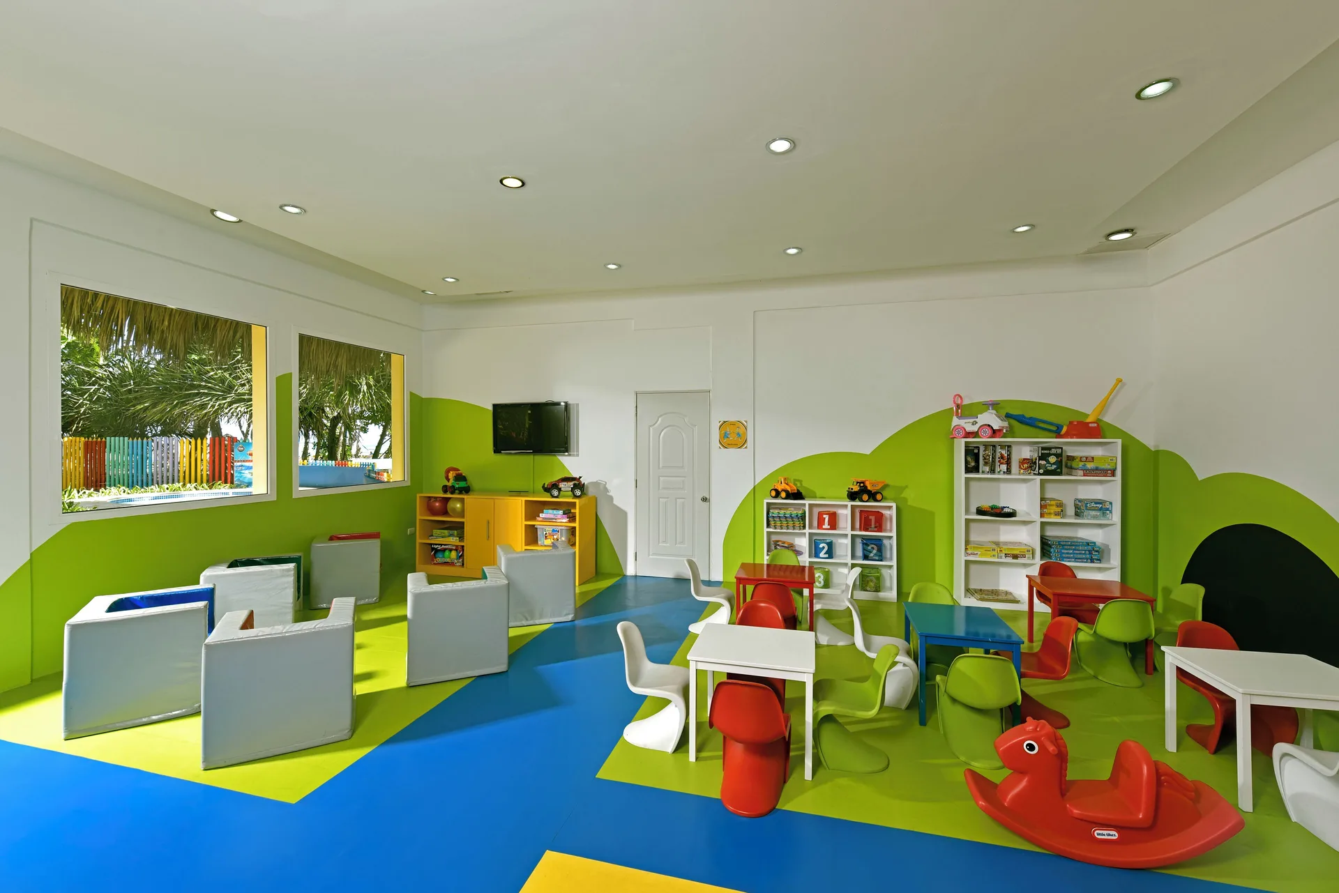 Colorful children's playroom with tables and toys at Iberostar Waves Costa Dorada.