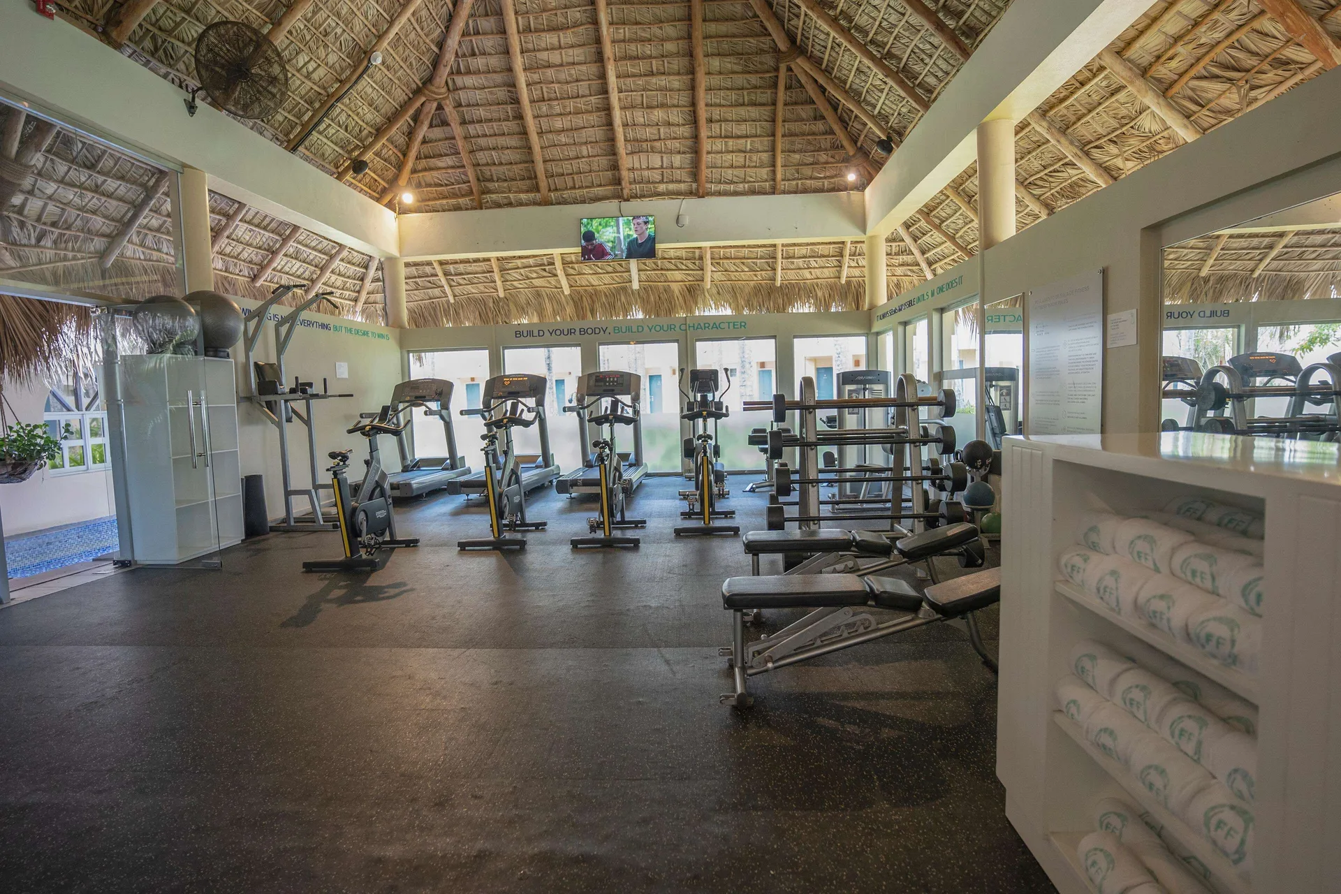 Fitness center with cardio machines and weights at Iberostar Waves Costa Dorada.