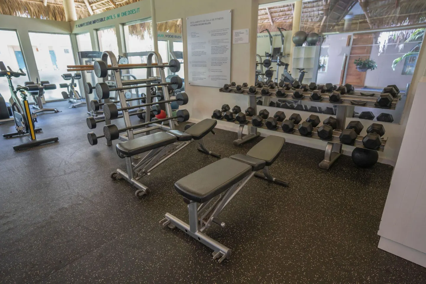 Fitness room with dumbbells and benches at Iberostar Waves Costa Dorada.