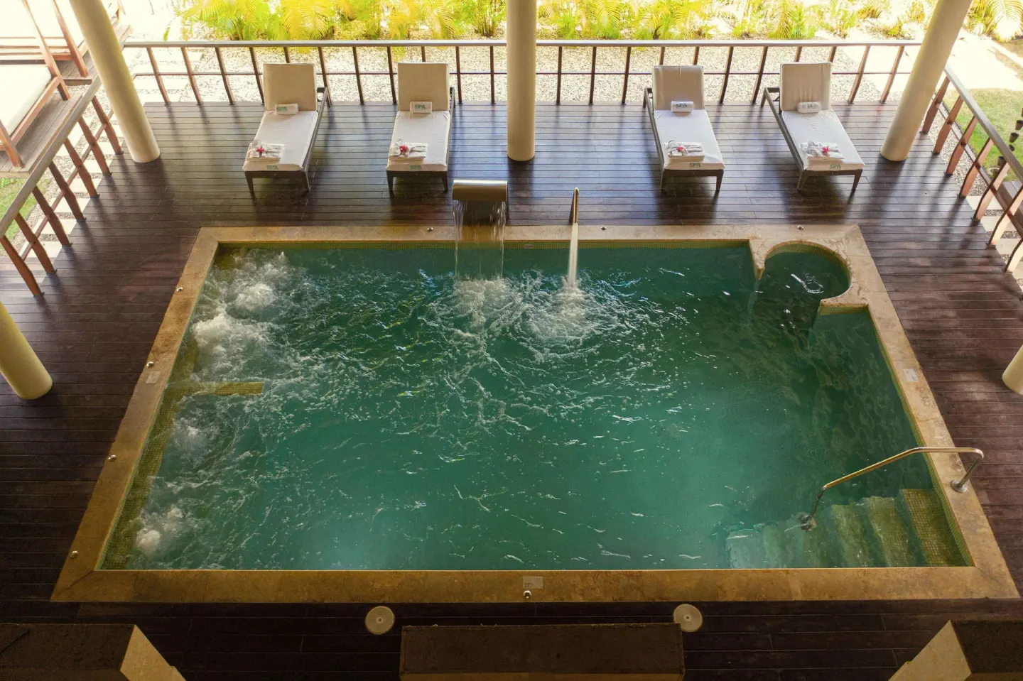 Hydrotherapy pool with jets and loungers at Iberostar Waves Costa Dorada.