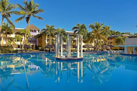 Main pool with decorative columns and palms at Iberostar Waves Costa Dorada.