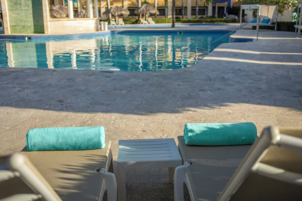 Two pool loungers with turquoise towels at Iberostar Waves Costa Dorada.