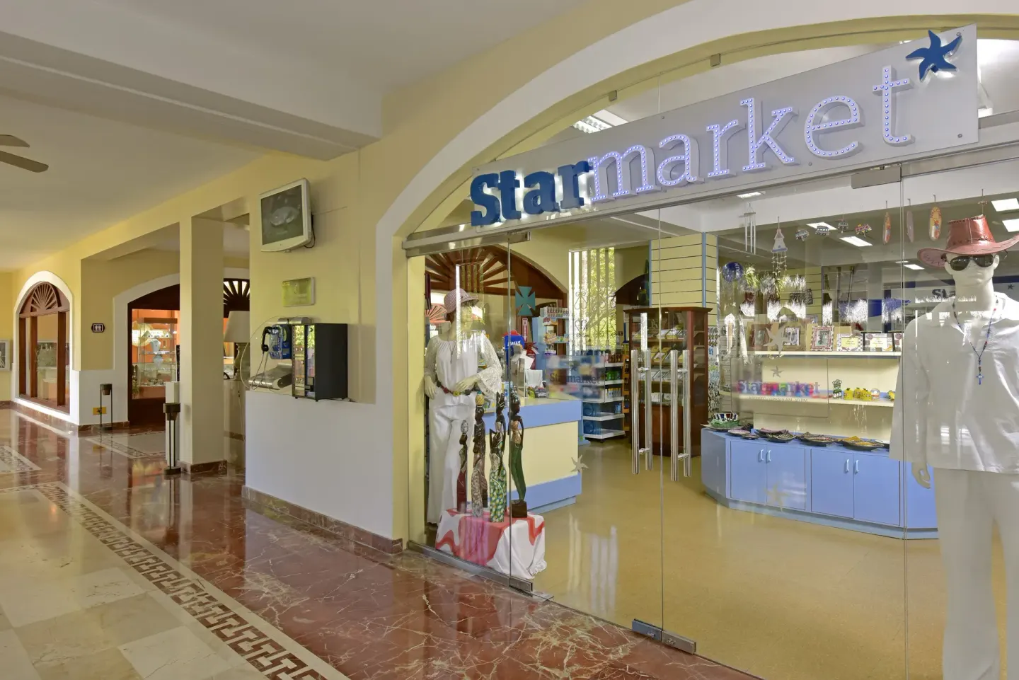Resort shop entrance with glass storefront at Iberostar Waves Costa Dorada.