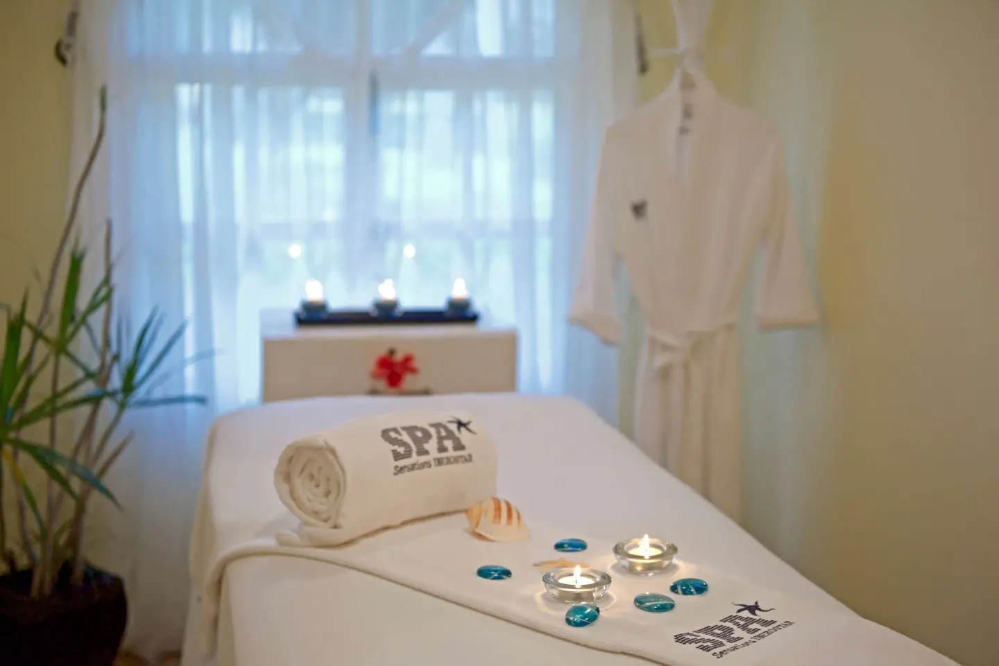 Spa treatment room with candles and robe at Iberostar Waves Costa Dorada.
