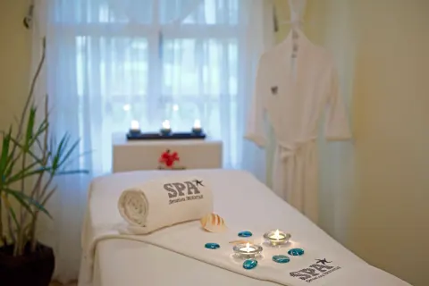 Spa treatment room with candles and robe at Iberostar Waves Costa Dorada.