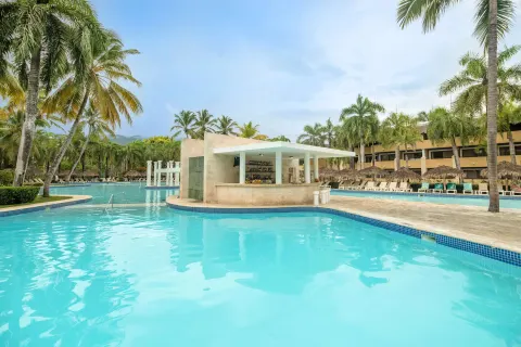 Swim-up pool bar surrounded by palm trees at Iberostar Waves Costa Dorada.