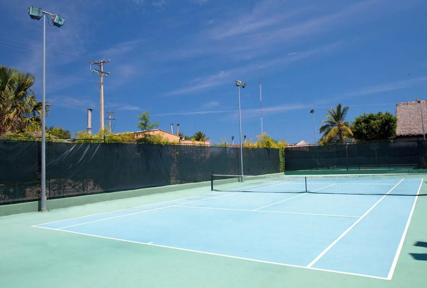 Tennis court with net and lights at Iberostar Waves Costa Dorada.
