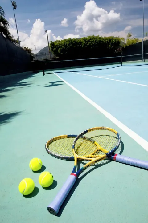 Tennis rackets and balls on a court at Iberostar Waves Costa Dorada.