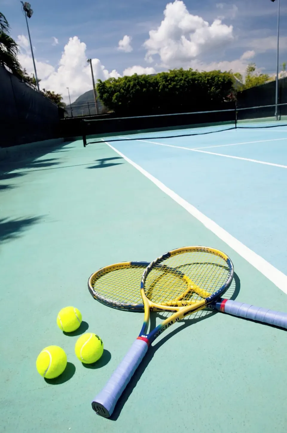 Tennis rackets and balls on a court at Iberostar Waves Costa Dorada.