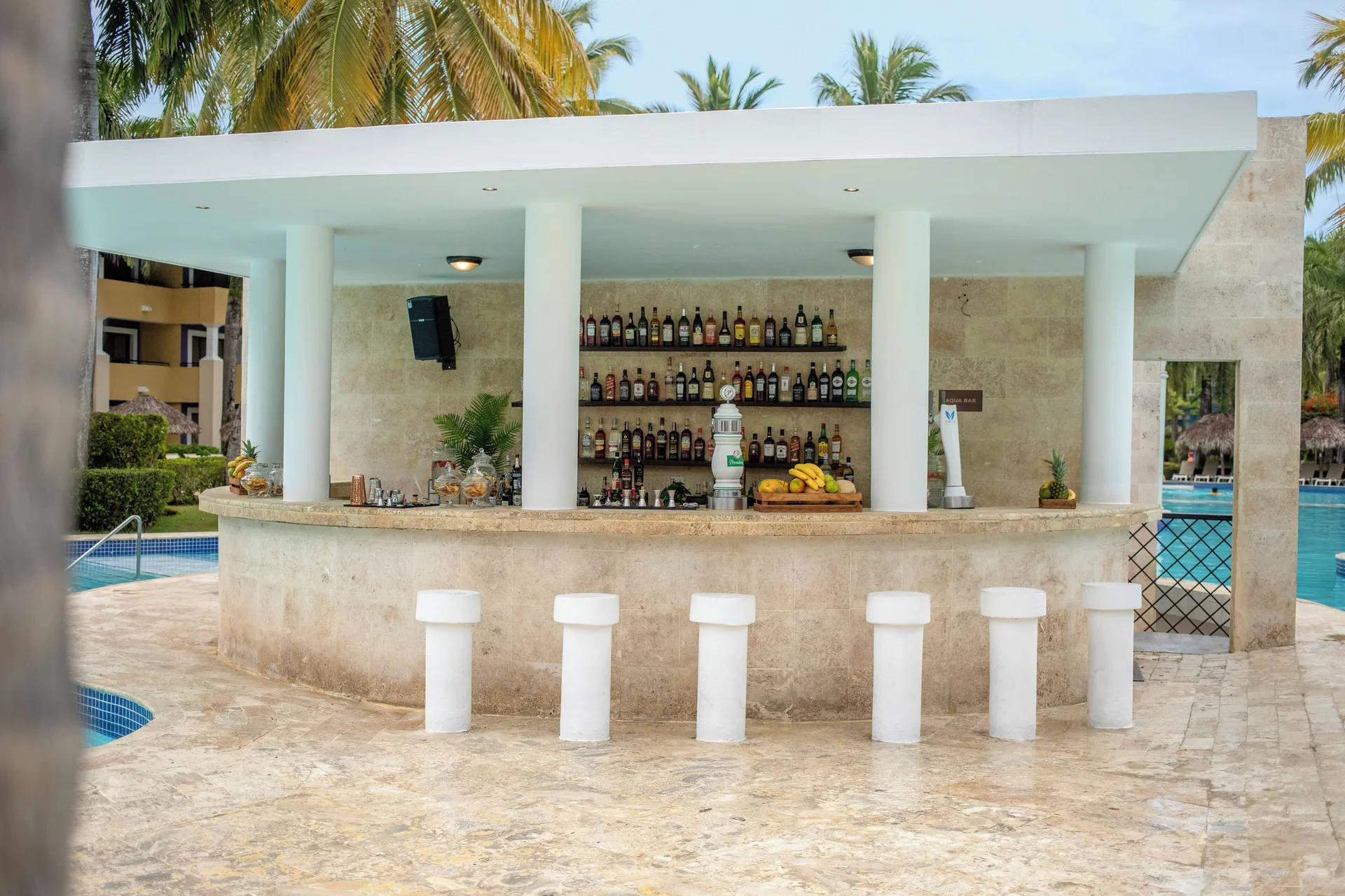 Swim-up pool bar with stools and liquor shelves at Iberostar Waves Costa Dorada.