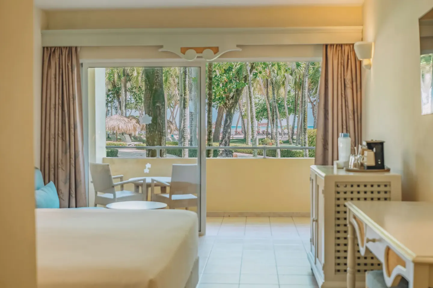 Premium Room Ocean View with bed, balcony, and palm-framed sea view at Iberostar Waves Costa Dorada.
