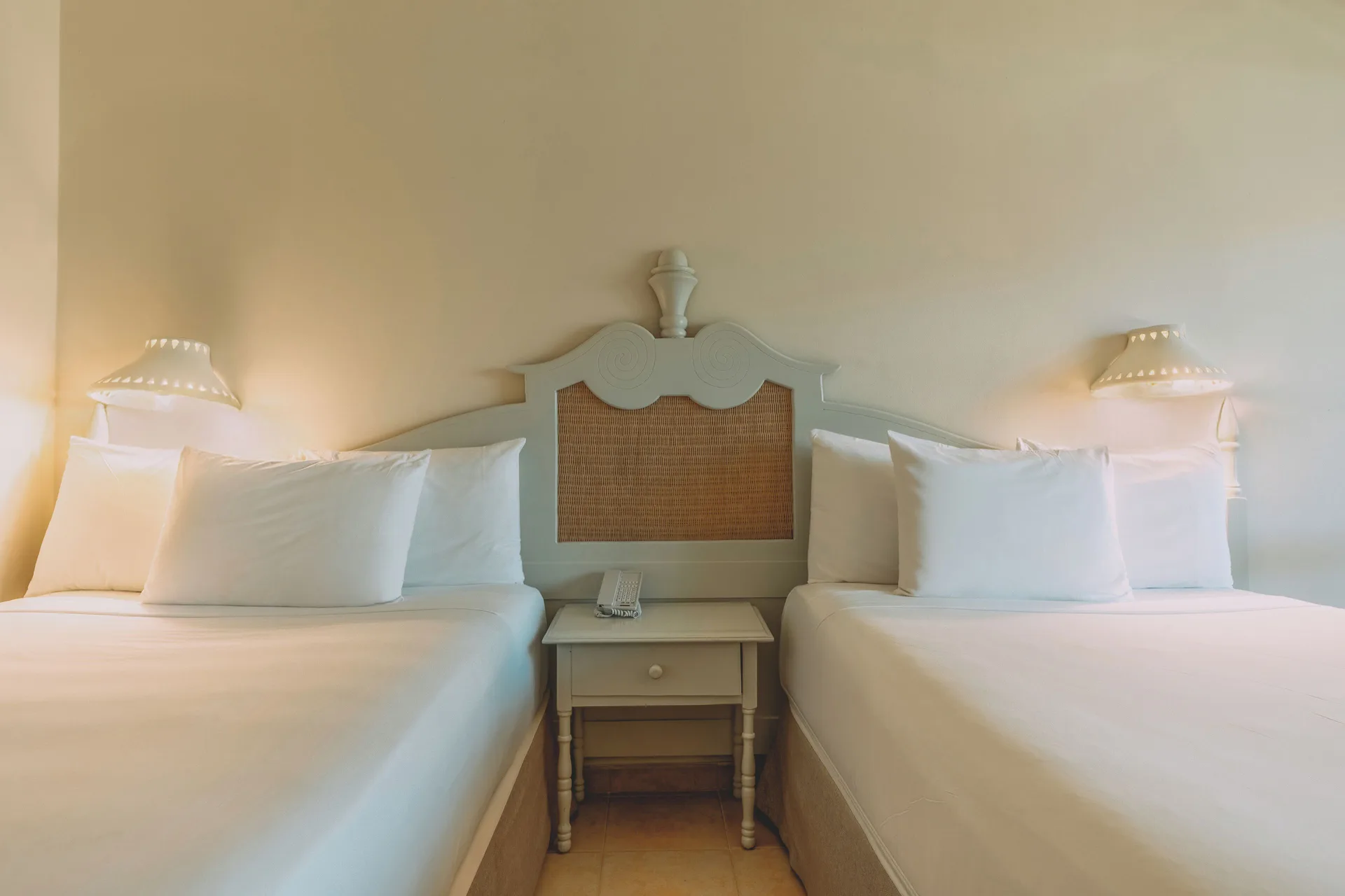 Premium Tropical View Room with two beds and bedside table at Iberostar Waves Costa Dorada.