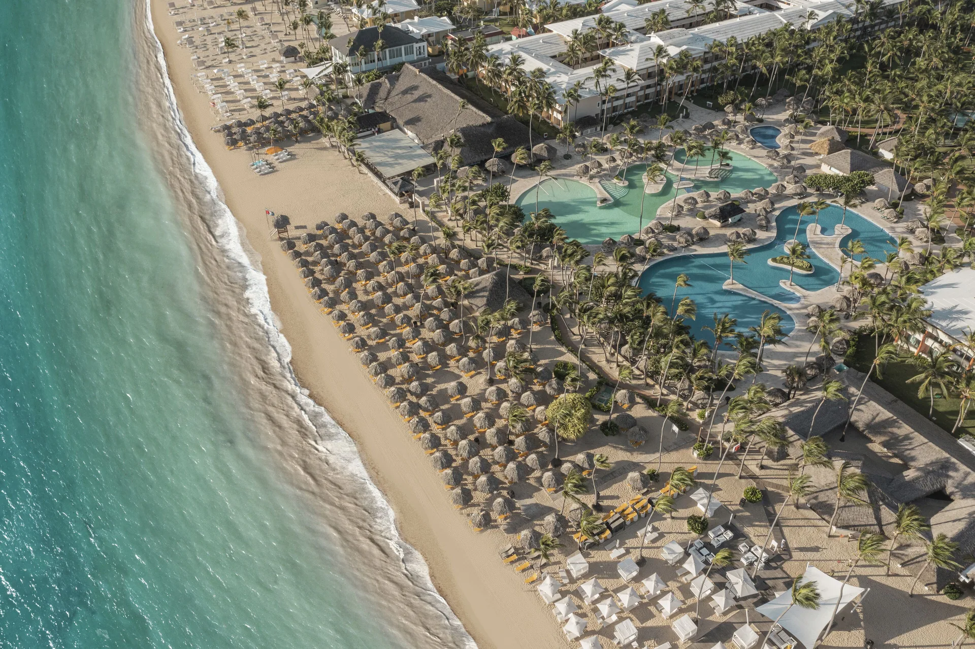 Aerial view of the beach, pools and palms at Iberostar Waves Dominicana.