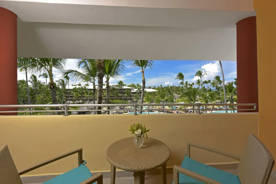 Balcony seating overlooks palms and pools at Iberostar Waves Dominicana.