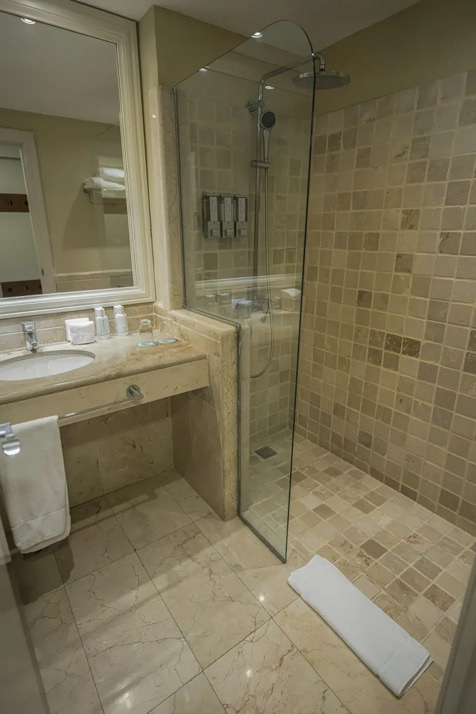 Bathroom vanity and glass shower in a guest room at Iberostar Waves Dominicana.
