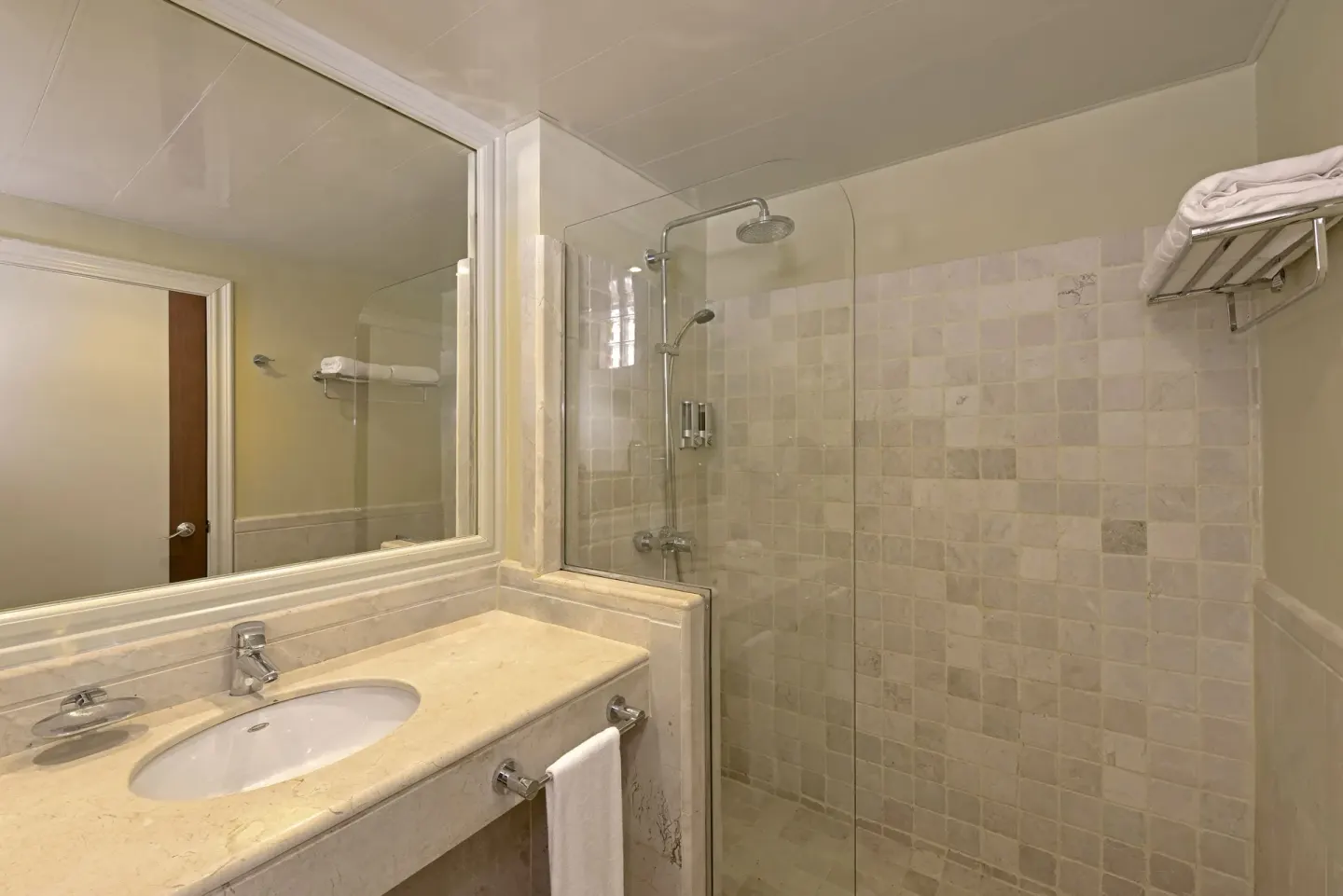 Guest bathroom with vanity, mirror, and glass shower at Iberostar Waves Dominicana.
