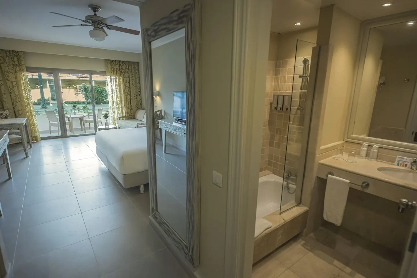 Guest room with king bed and bathroom vanity at Iberostar Waves Dominicana.