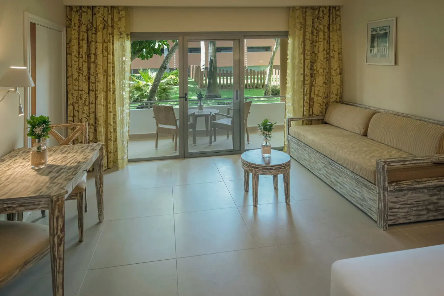 Sitting area with sofa and patio doors in a guest room at Iberostar Waves Dominicana.