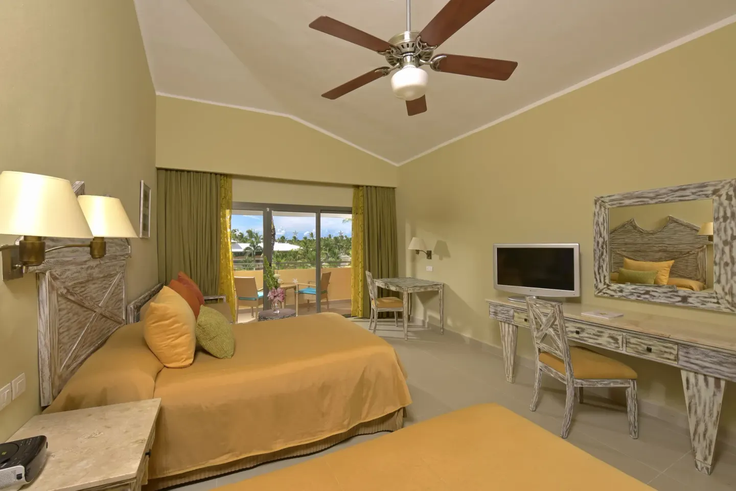 Guest room with two beds, yellow bedding and balcony view at Iberostar Waves Dominicana.