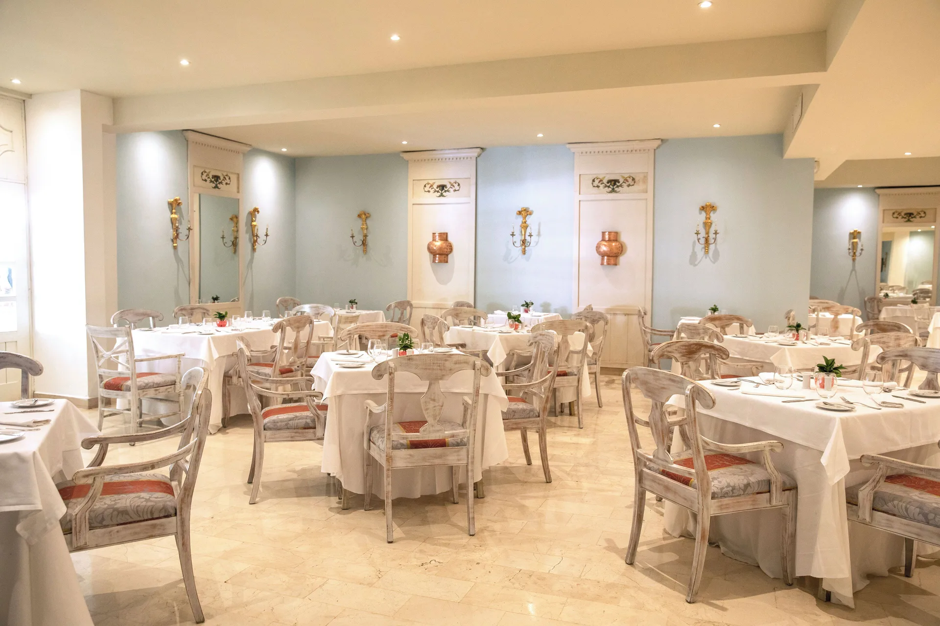 Elegant dining room with white tablecloths and pale chairs at Iberostar Waves Dominicana.