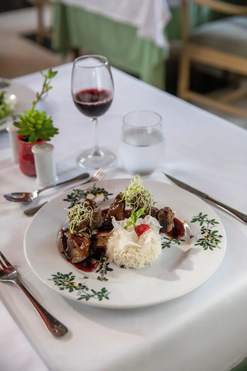 Plated meat dish with rice and red wine at Iberostar Waves Dominicana.