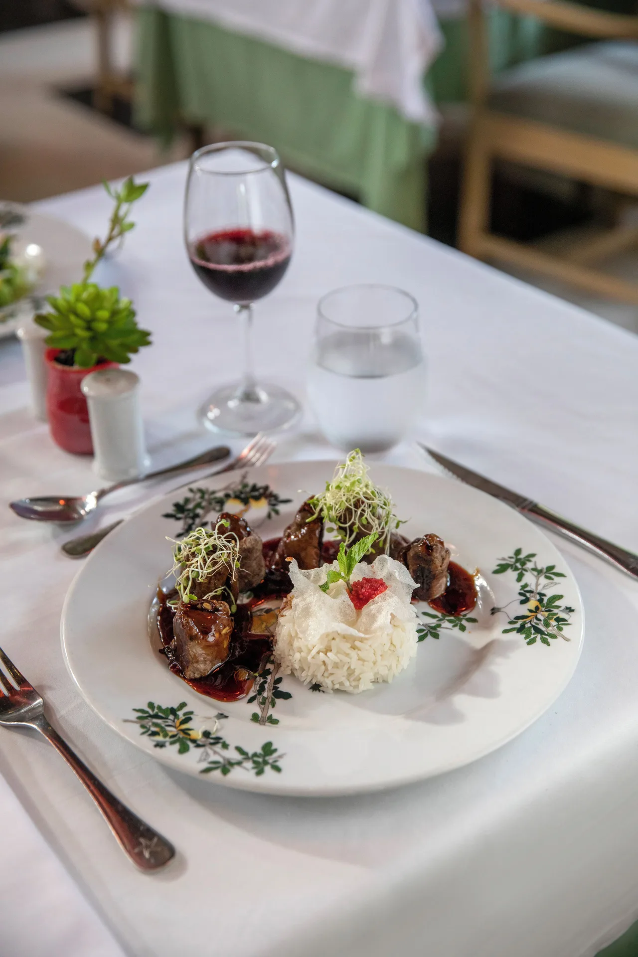 Plated meat dish with rice and red wine at Iberostar Waves Dominicana.