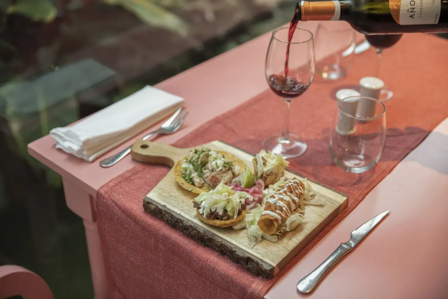 Small tacos and red wine on a restaurant table at Iberostar Waves Dominicana.