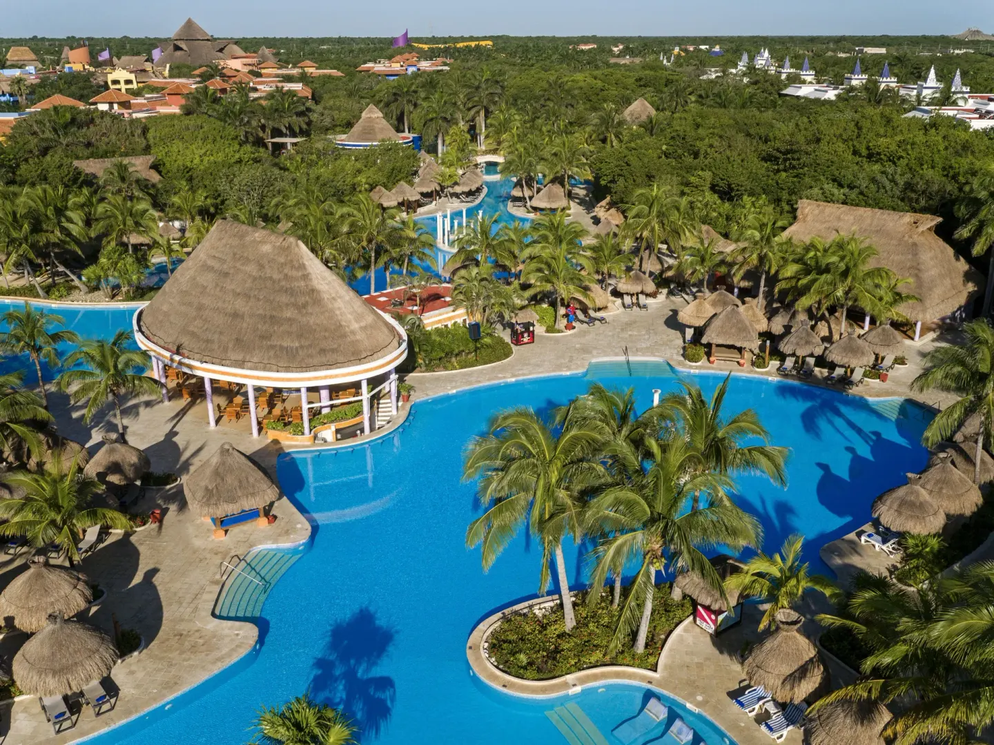 Aerial pool area with palapas and palms at Iberostar Waves Paraíso Beach.