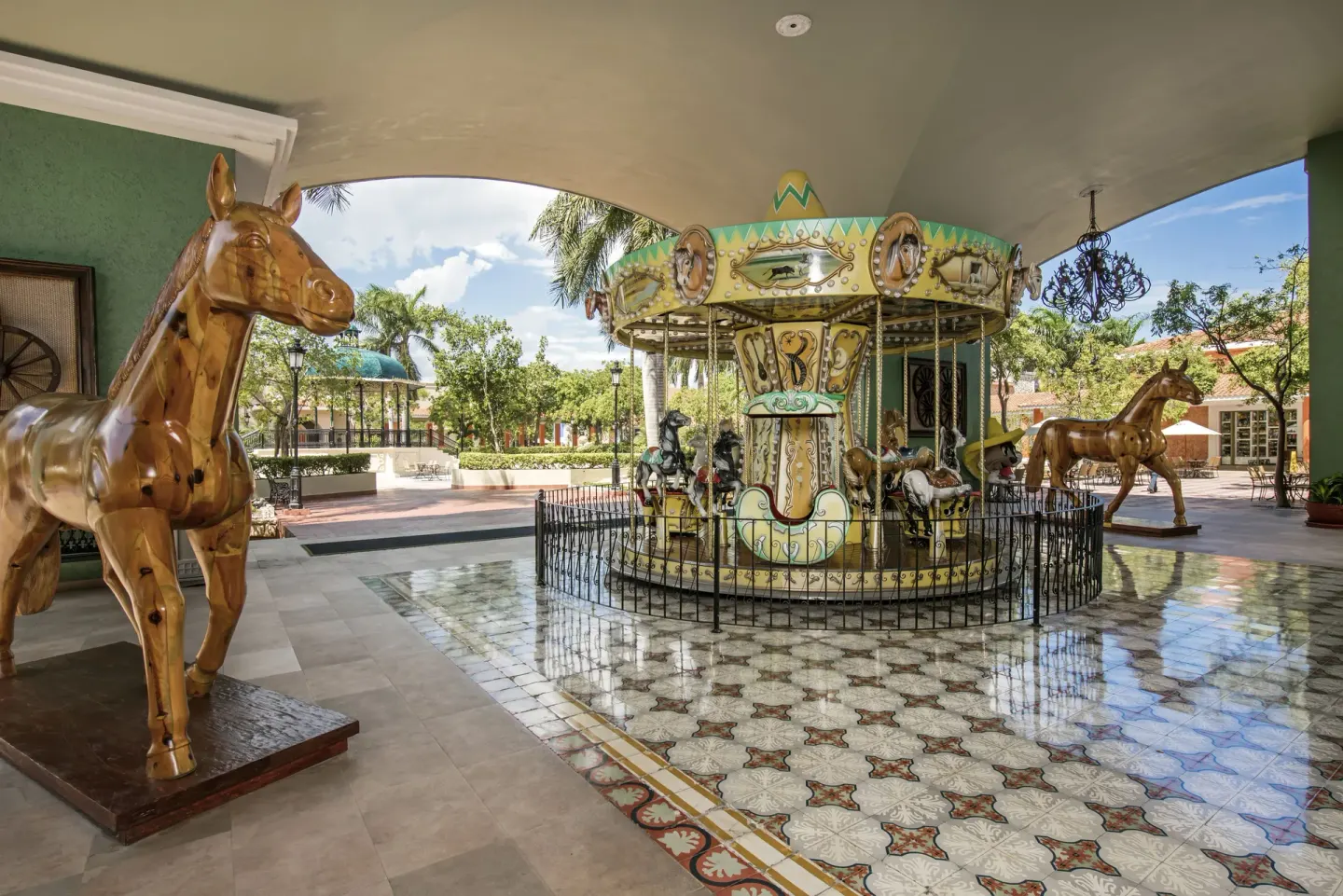 Covered carousel with decorative horses at Iberostar Waves Paraíso Beach.