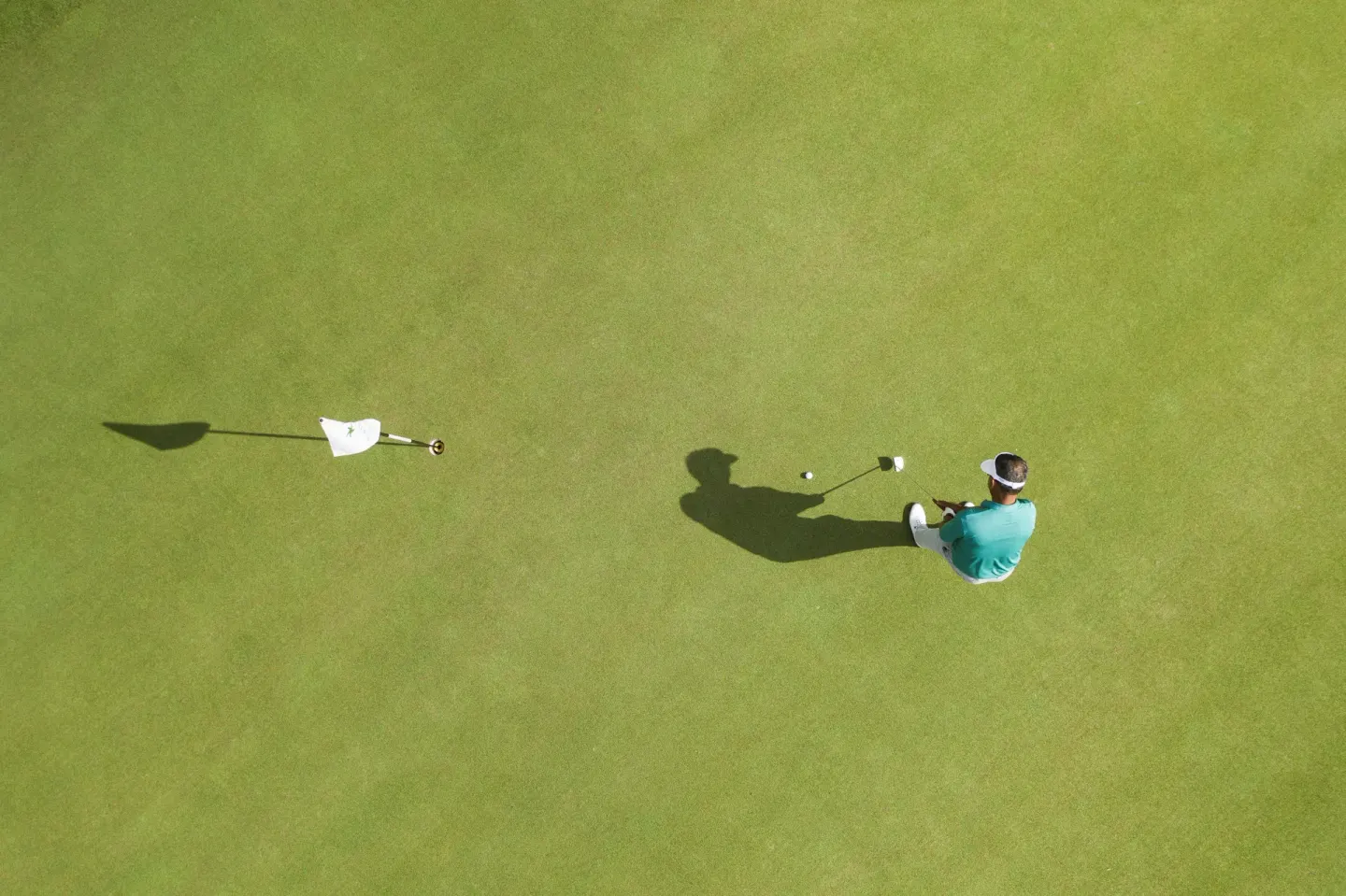 A golfer lines up a putt on a green at Iberostar Waves Paraíso Beach.
