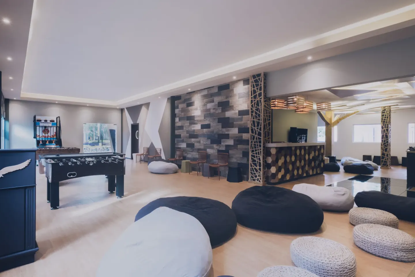 Indoor lounge with foosball, beanbags, and seating at Iberostar Waves Paraíso Beach.