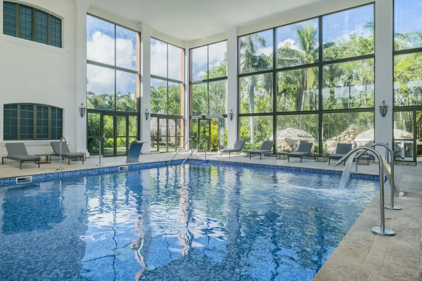 Indoor pool corner with water jets and palm views at Iberostar Waves Paraíso Beach.