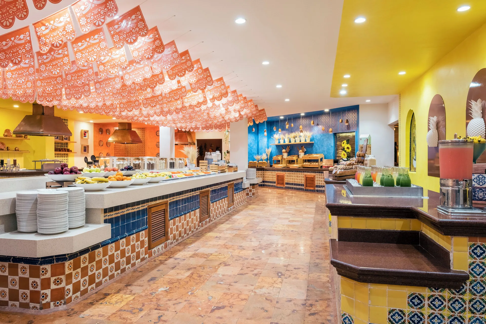 Colorful buffet counters and juice dispensers at Iberostar Waves Paraíso Beach.