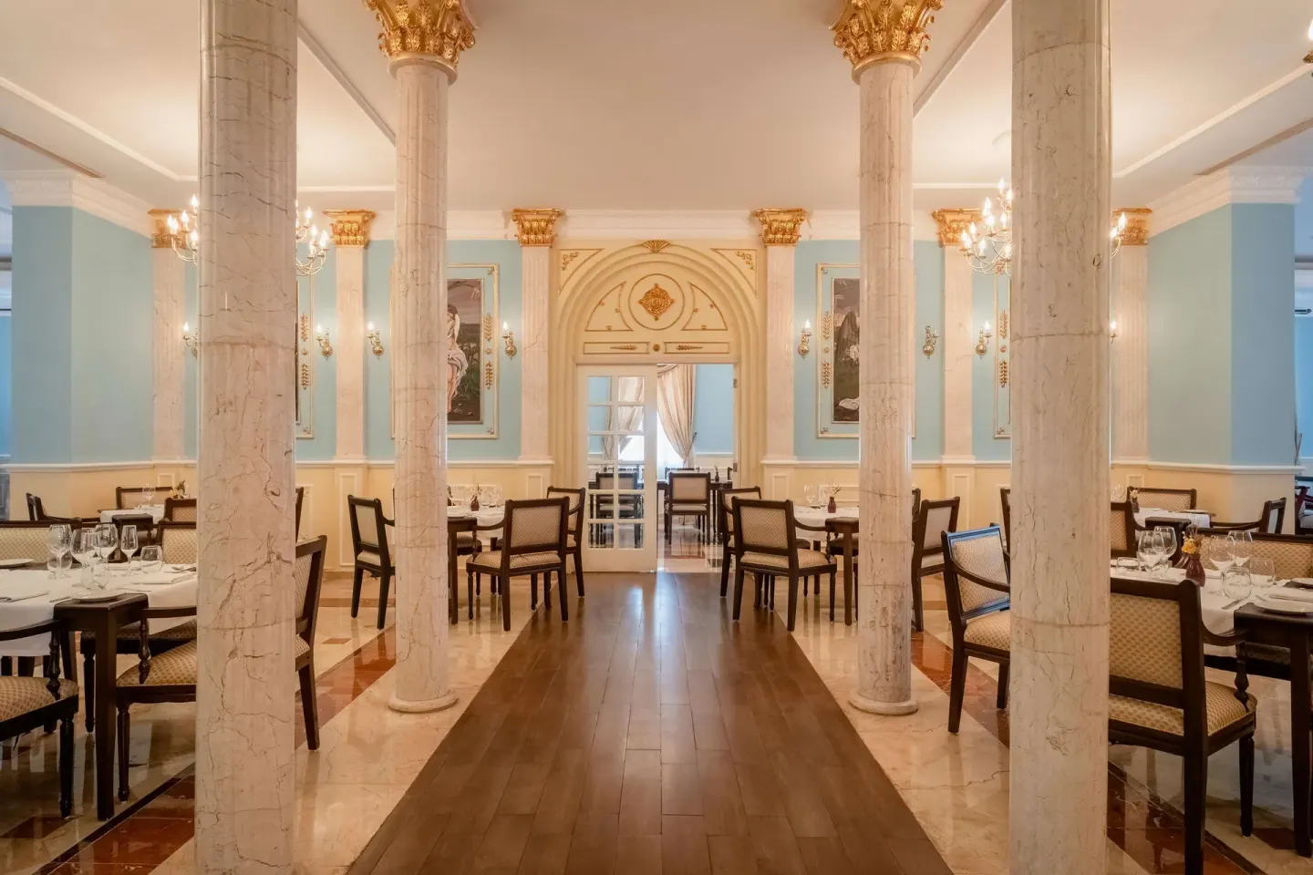 Elegant dining room with columns and pale blue walls at Iberostar Waves Paraíso Beach.