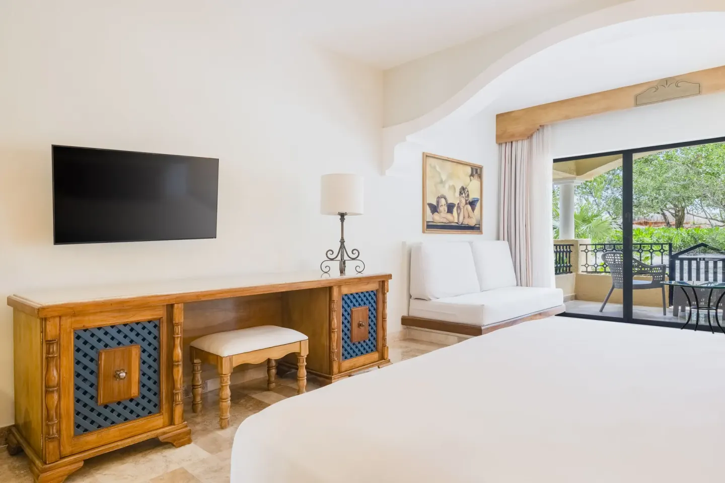 Junior Suite at Iberostar Waves Paraíso Beach showing the TV console, daybed, king bed, and terrace doors.
