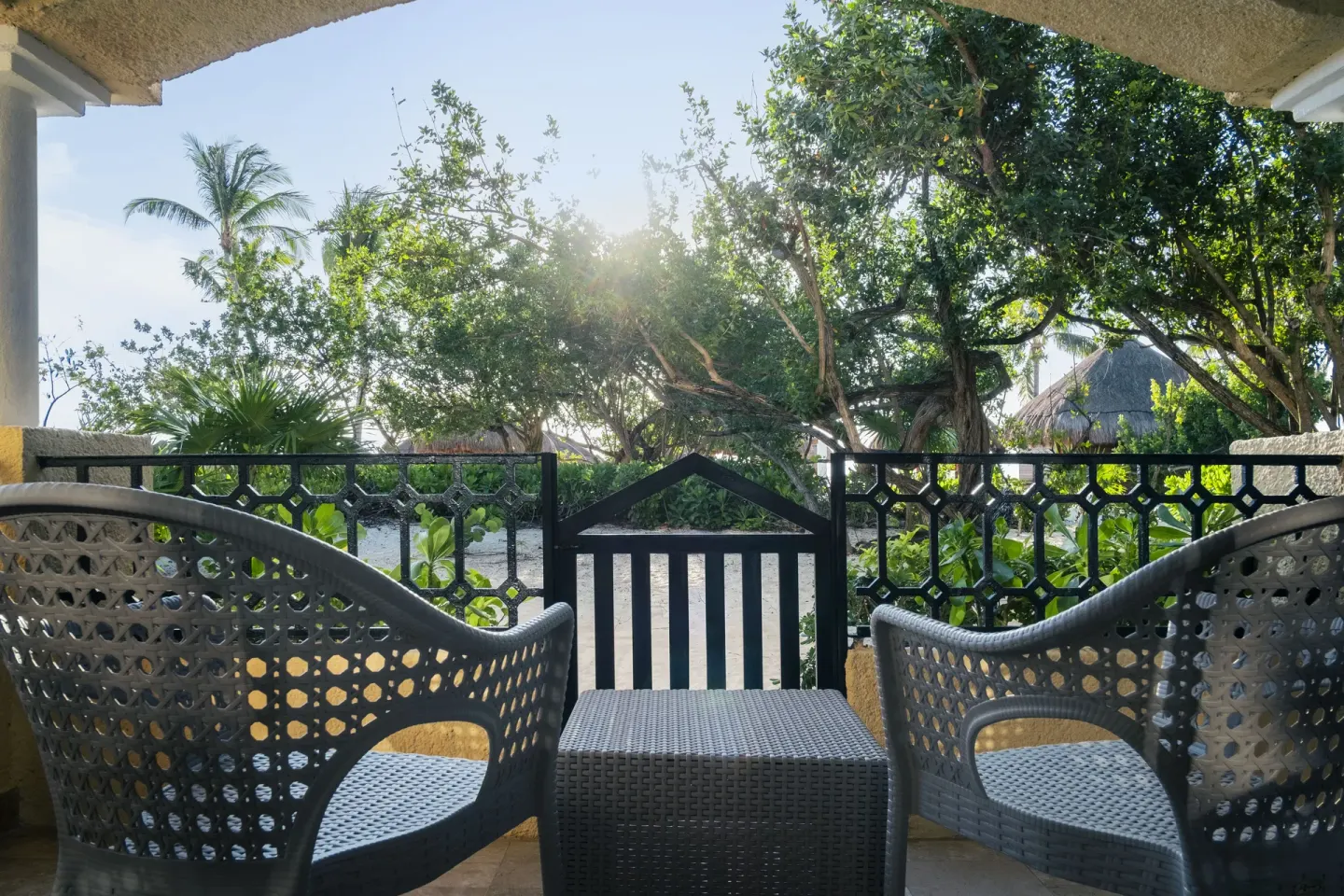 Beach access terrace at Iberostar Waves Paraíso Beach with two chairs, a table, and garden path beyond.